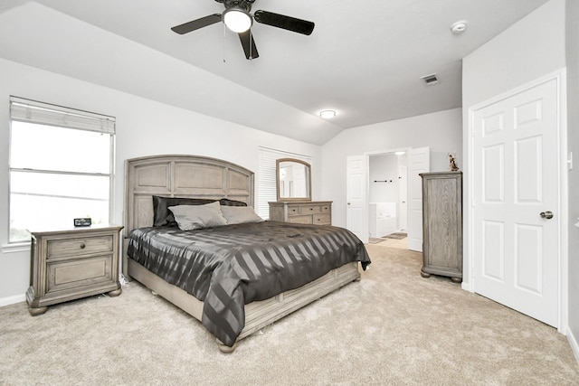 carpeted bedroom with ceiling fan, lofted ceiling, and ensuite bath