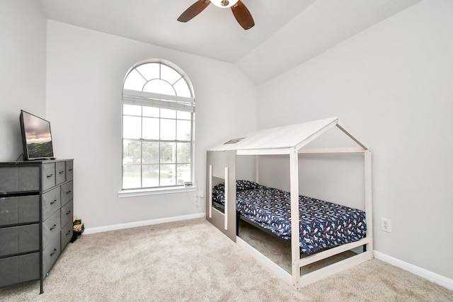 carpeted bedroom with ceiling fan, multiple windows, and lofted ceiling