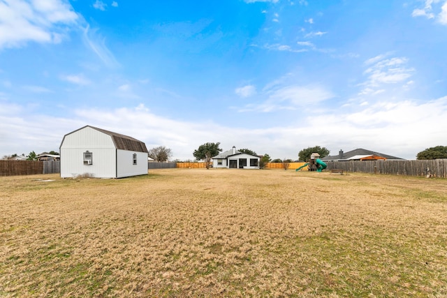 view of yard with a storage shed and a playground