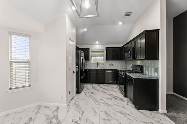 kitchen with black appliances, light stone countertops, decorative backsplash, sink, and vaulted ceiling