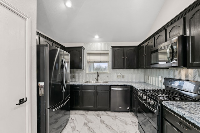 kitchen with sink, backsplash, light stone countertops, lofted ceiling, and stainless steel appliances