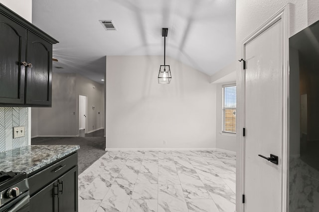 interior space featuring stove, pendant lighting, dark stone counters, and lofted ceiling