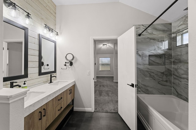 bathroom featuring vanity, vaulted ceiling, wooden walls, and tiled shower / bath combo