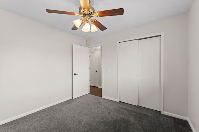 unfurnished bedroom featuring dark carpet, a closet, and ceiling fan