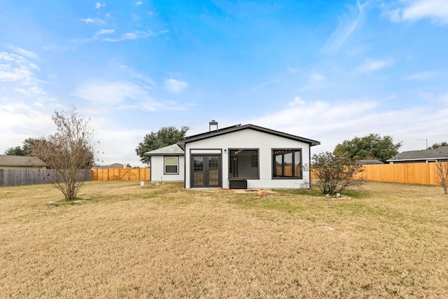 back of house featuring a yard and french doors