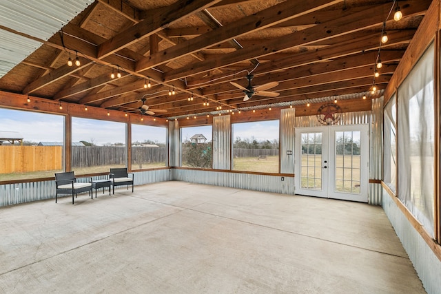 unfurnished sunroom featuring ceiling fan and french doors