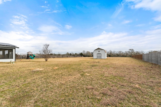 view of yard with a playground and a storage unit