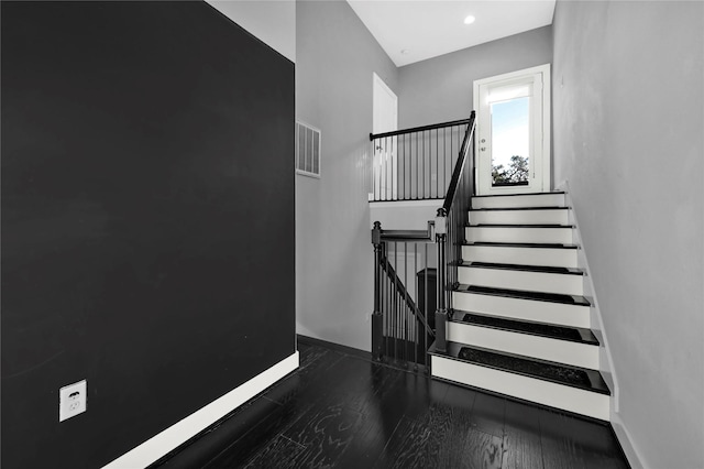 stairs featuring hardwood / wood-style floors