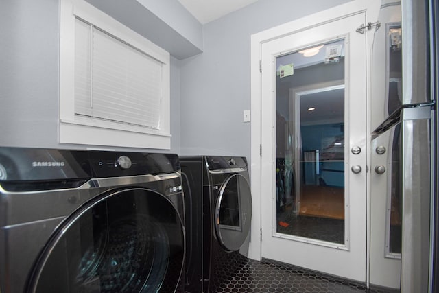 laundry room with dark tile patterned floors and washer and dryer