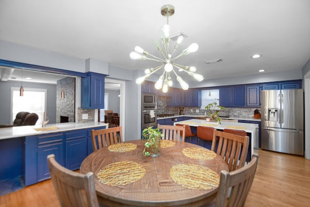 dining room featuring sink, plenty of natural light, a notable chandelier, and light hardwood / wood-style floors