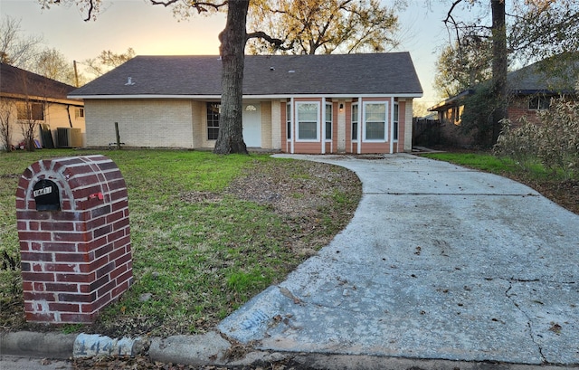 ranch-style house featuring central AC and a lawn