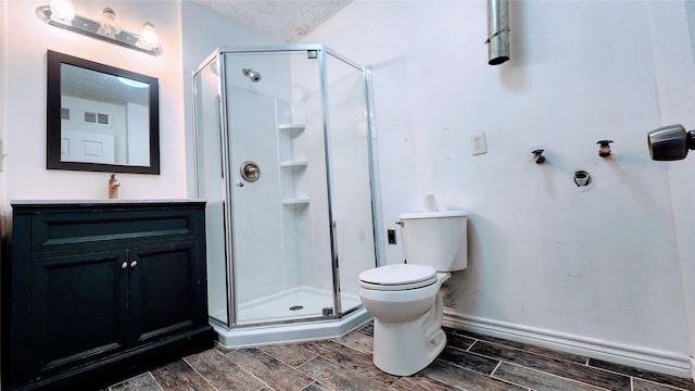 bathroom with a shower with door, vanity, a textured ceiling, and toilet