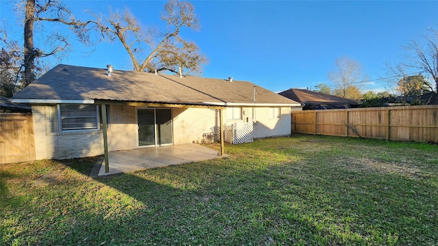 rear view of house featuring a lawn and a patio area