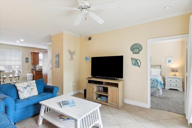 living room featuring ceiling fan, crown molding, and light carpet