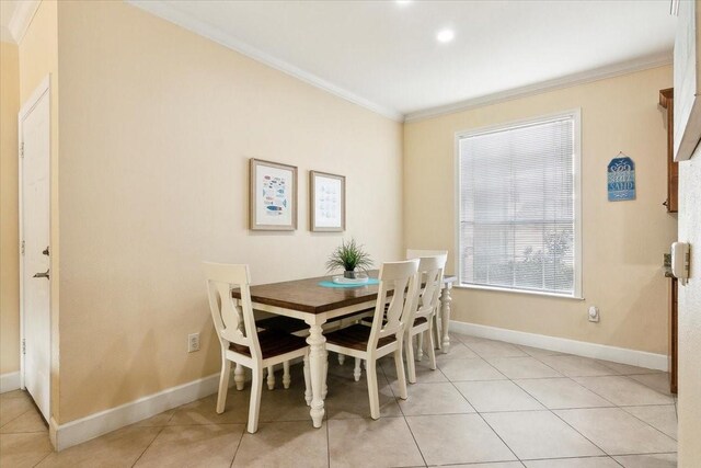 dining area with light tile patterned floors and ornamental molding