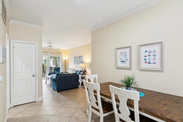 dining space with ceiling fan, ornamental molding, and light tile patterned floors