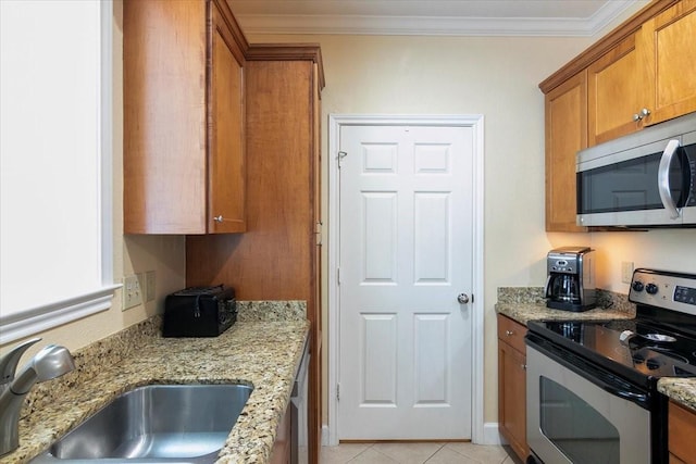 kitchen with light stone countertops, appliances with stainless steel finishes, sink, ornamental molding, and light tile patterned flooring