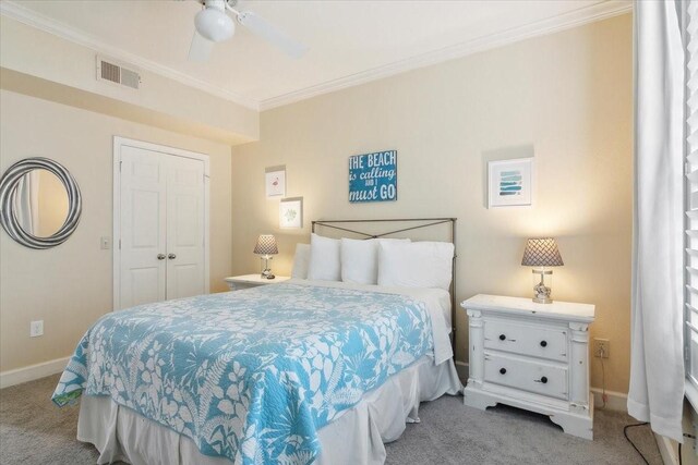 bedroom featuring light carpet, a closet, ceiling fan, and crown molding