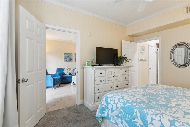 carpeted bedroom with ceiling fan and ornamental molding