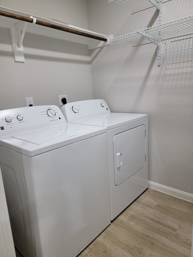 washroom with light hardwood / wood-style floors and independent washer and dryer