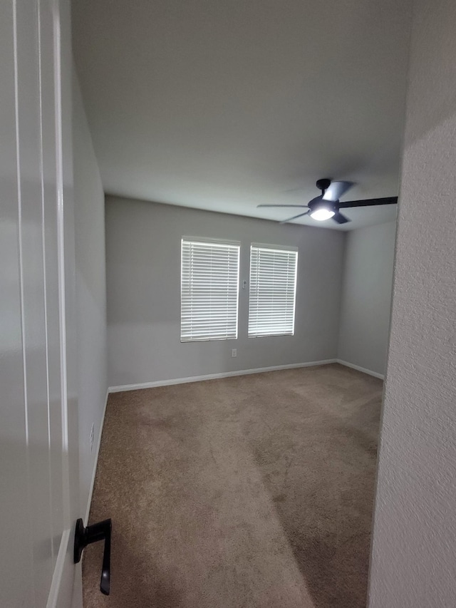 unfurnished room featuring ceiling fan and carpet flooring