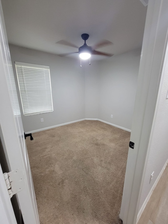 spare room with light carpet and ceiling fan