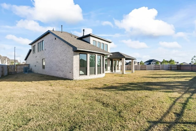 back of property featuring cooling unit and a lawn