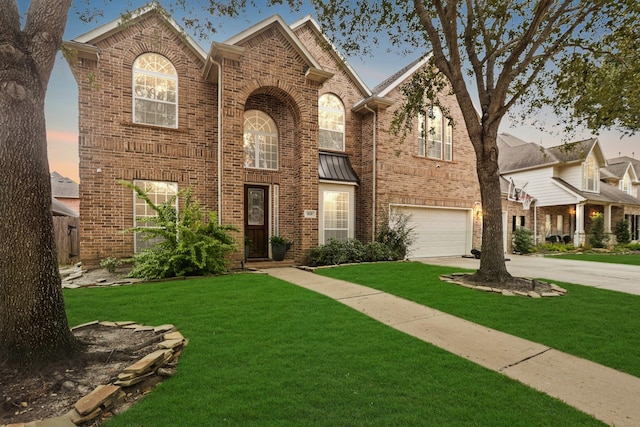 view of front of property with a garage and a yard