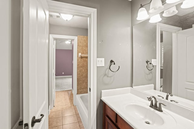 bathroom with tile patterned flooring, vanity, and a tub