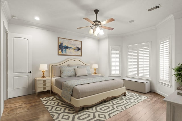 bedroom featuring hardwood / wood-style flooring, ornamental molding, and ceiling fan