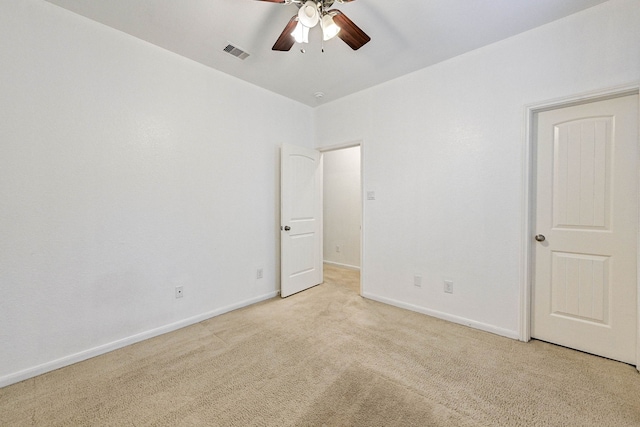 empty room featuring ceiling fan and light colored carpet