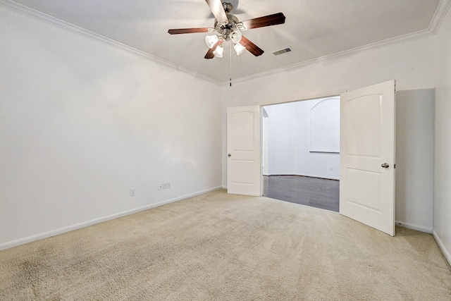 carpeted spare room with ceiling fan and ornamental molding