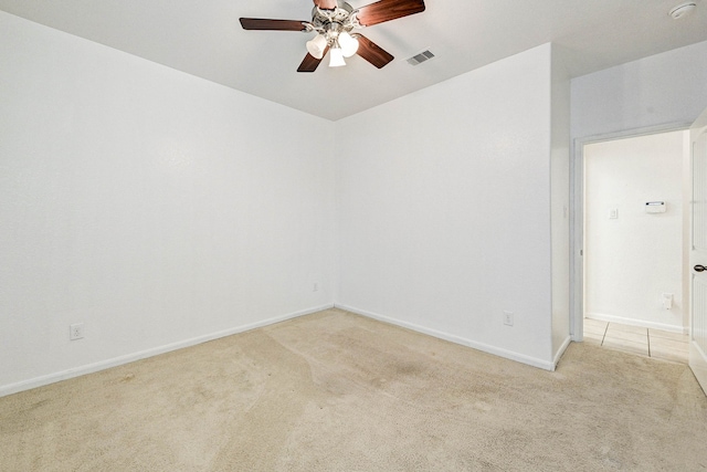 spare room featuring light colored carpet and ceiling fan