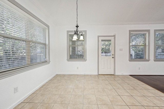 unfurnished dining area featuring an inviting chandelier, light tile patterned floors, and ornamental molding