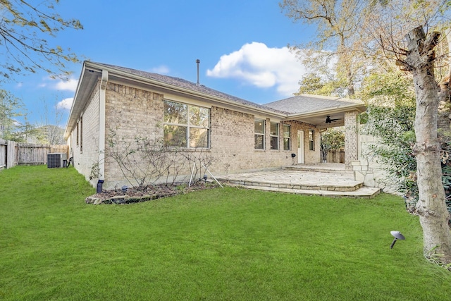 back of property with central AC unit, a patio area, a yard, and ceiling fan