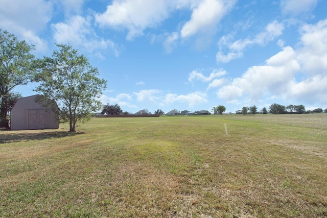 view of yard featuring a storage shed and a rural view