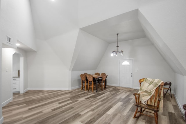 interior space with vaulted ceiling, a chandelier, and light hardwood / wood-style floors