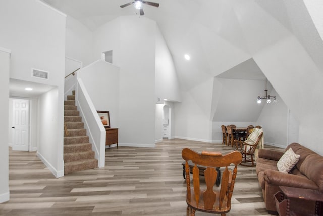 living room featuring light hardwood / wood-style floors, high vaulted ceiling, and ceiling fan