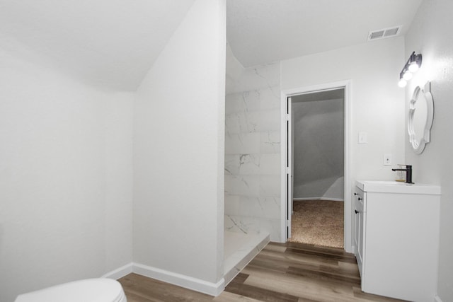 bathroom featuring vanity, toilet, walk in shower, and hardwood / wood-style floors