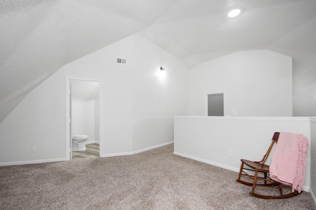 unfurnished room featuring carpet and lofted ceiling