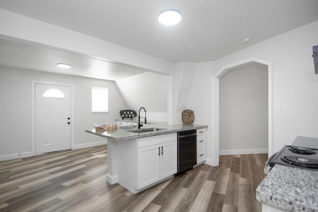 kitchen featuring black dishwasher, white cabinetry, sink, kitchen peninsula, and light stone counters