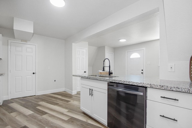 kitchen featuring white cabinetry, sink, dishwashing machine, light hardwood / wood-style flooring, and light stone counters