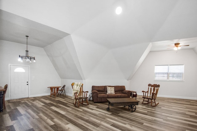 living area with hardwood / wood-style flooring, vaulted ceiling, and an inviting chandelier