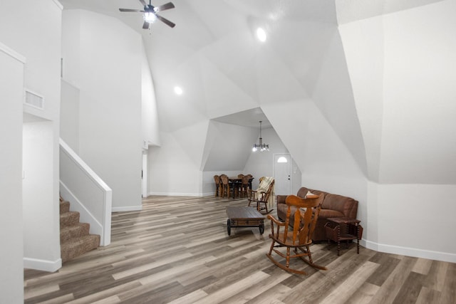 sitting room with ceiling fan, light wood-type flooring, and vaulted ceiling