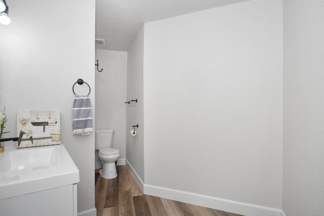 bathroom with sink, toilet, and hardwood / wood-style floors