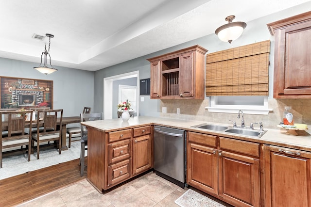 kitchen with dishwasher, sink, decorative light fixtures, kitchen peninsula, and backsplash