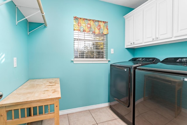 clothes washing area with light tile patterned floors, separate washer and dryer, and cabinets