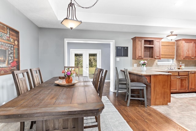 dining area featuring sink, french doors, and wood-type flooring