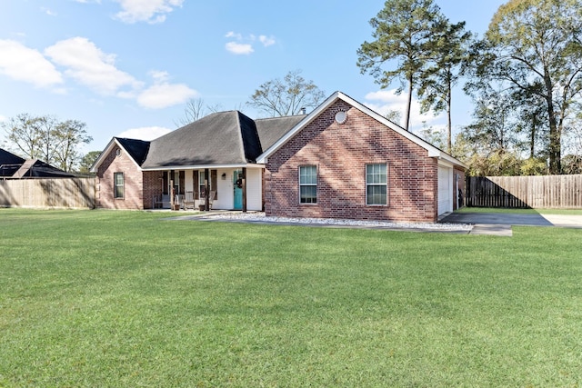 view of front of property featuring covered porch, a front yard, and a garage