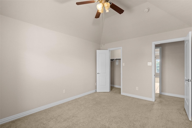 unfurnished bedroom with ceiling fan, light colored carpet, a closet, and vaulted ceiling